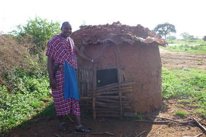 Ein Massai vor einer selbstgebauten Hütte