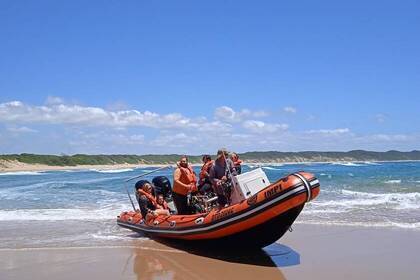 Motorboot mit Freiwilligen kommt am Strand an 