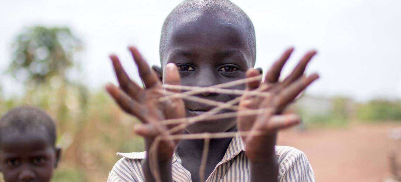 African boy plays with a string