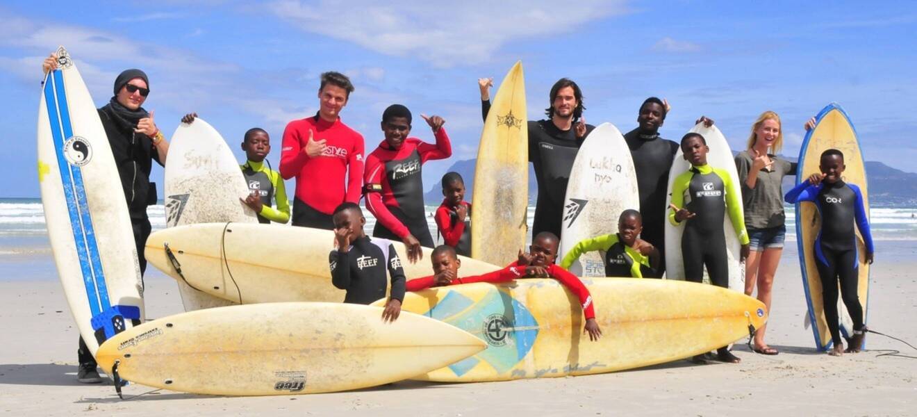 Volunteers and children in the surfing project