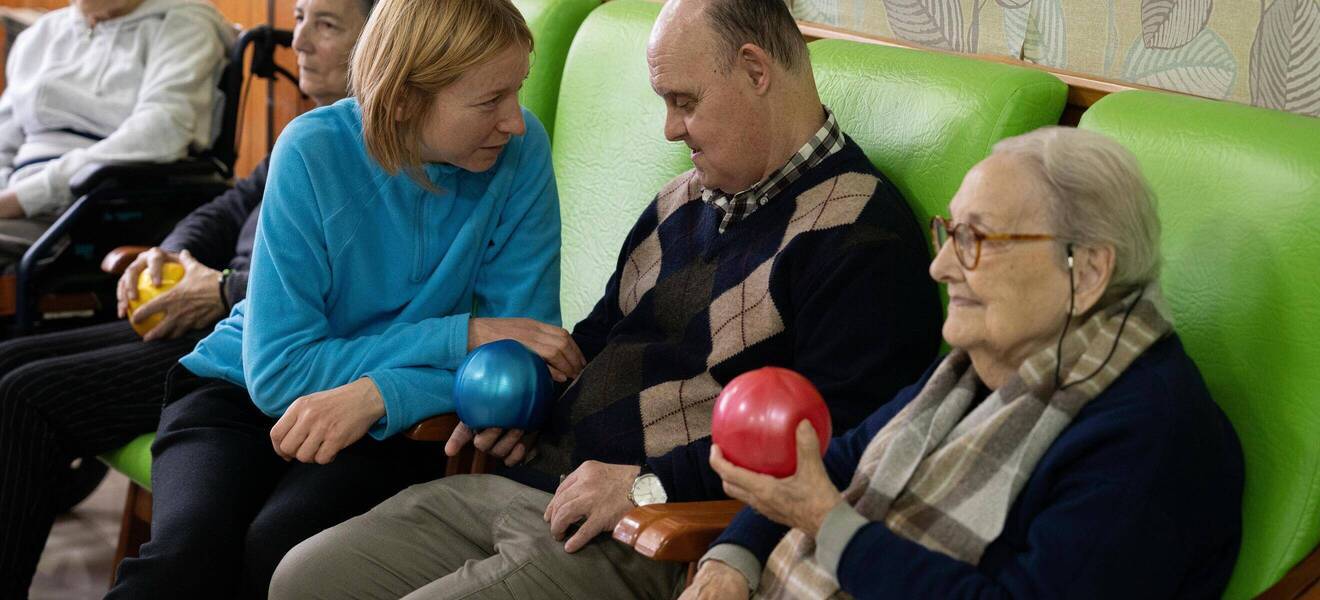 Volunteers spielen mit Senior:innen ein Wurf- Spiel