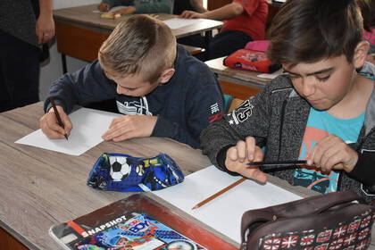 School children write in a school project in Romania