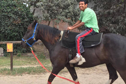 Jugendlicher auf einem Pferd bei der Reittherapie