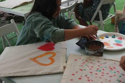 Volunteering in art therapy - child paints cloth bag