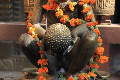 Statue und Gebetsmühlen in einem Tempel