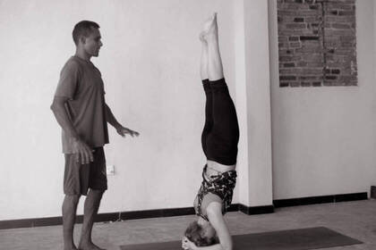 Yoga teacher instructs a student in a yoga session