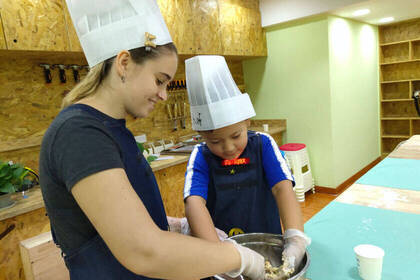 Volunteer backt mit Kind