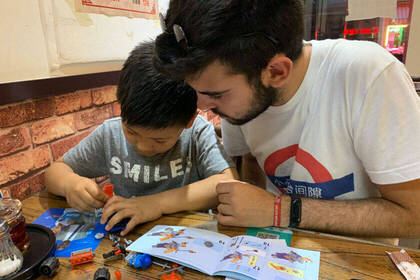 Volunteer baut Lego mit Kind