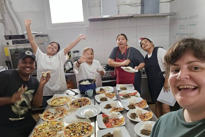 Freiwillige Helfer präsentieren die fertig gekochten Gerichte
